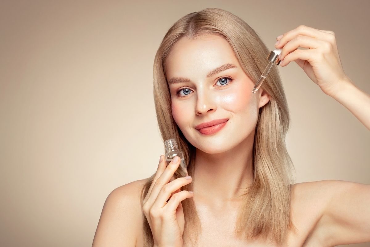 Zdjęcie przedstawia kobietę, która nakłada na twarz kolagen