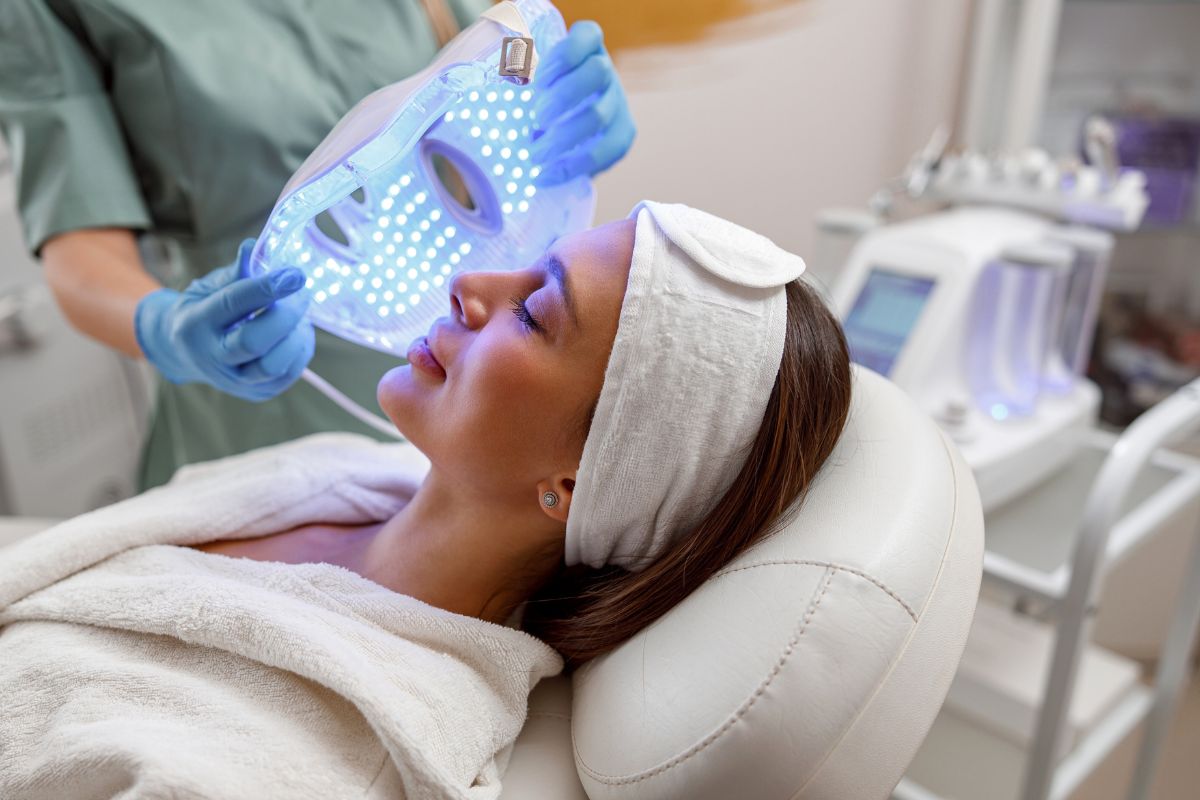 Kobieta korzysta z zabiegu maską LED w gabinecie medycyny estetycznej
