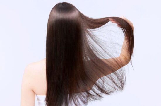 Kobieta cieszy się lśniącymi włosami po botoksie