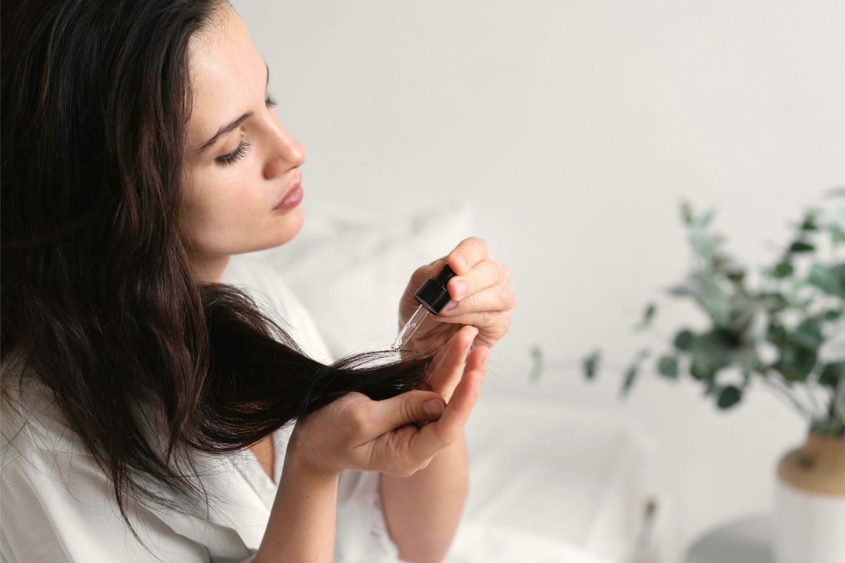 Kobieta aplikuje olej do włosów na końcówki