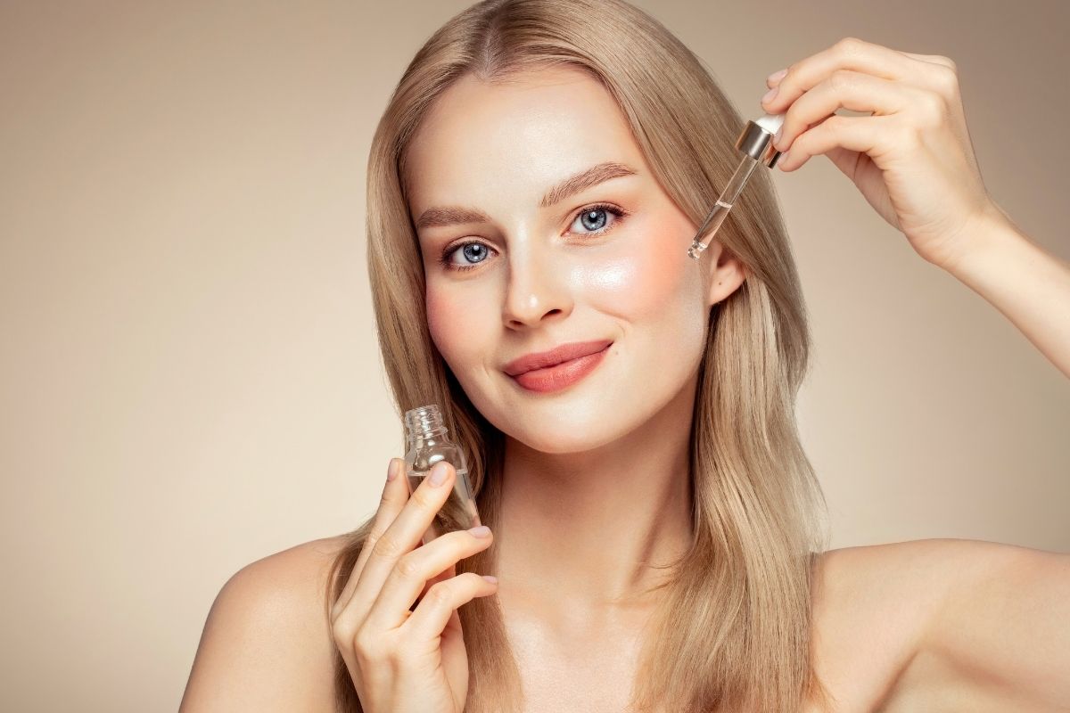 Kobieta aplikuje serum nawilżające do twarzy