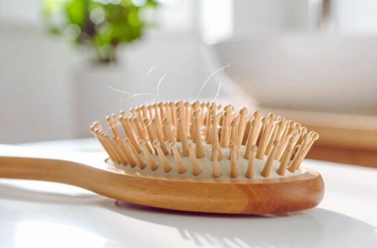 więcej włosów na szczotce po czesaniu to jeden z objawów nadmiernego wypadania włosów u kobiet