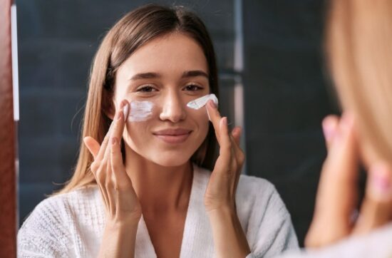 fotografia przedstawia kobietę, która nakłada na twarz krem