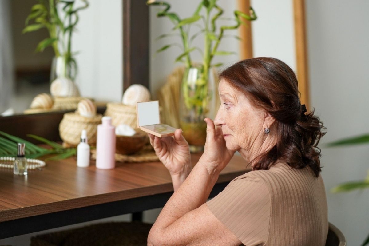 Zdjęcie przedstawia kobietę, która przegląda się w lusterku